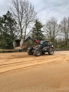 Mit Radladern wird der Dolomitsand verteilt.